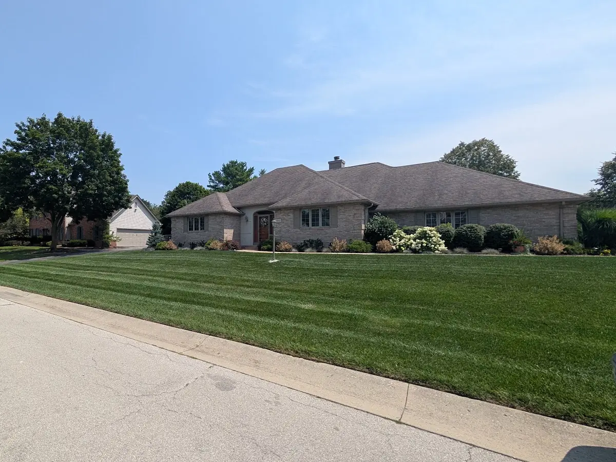Freshly mowed lawn with stripes in front of a brick ranch house