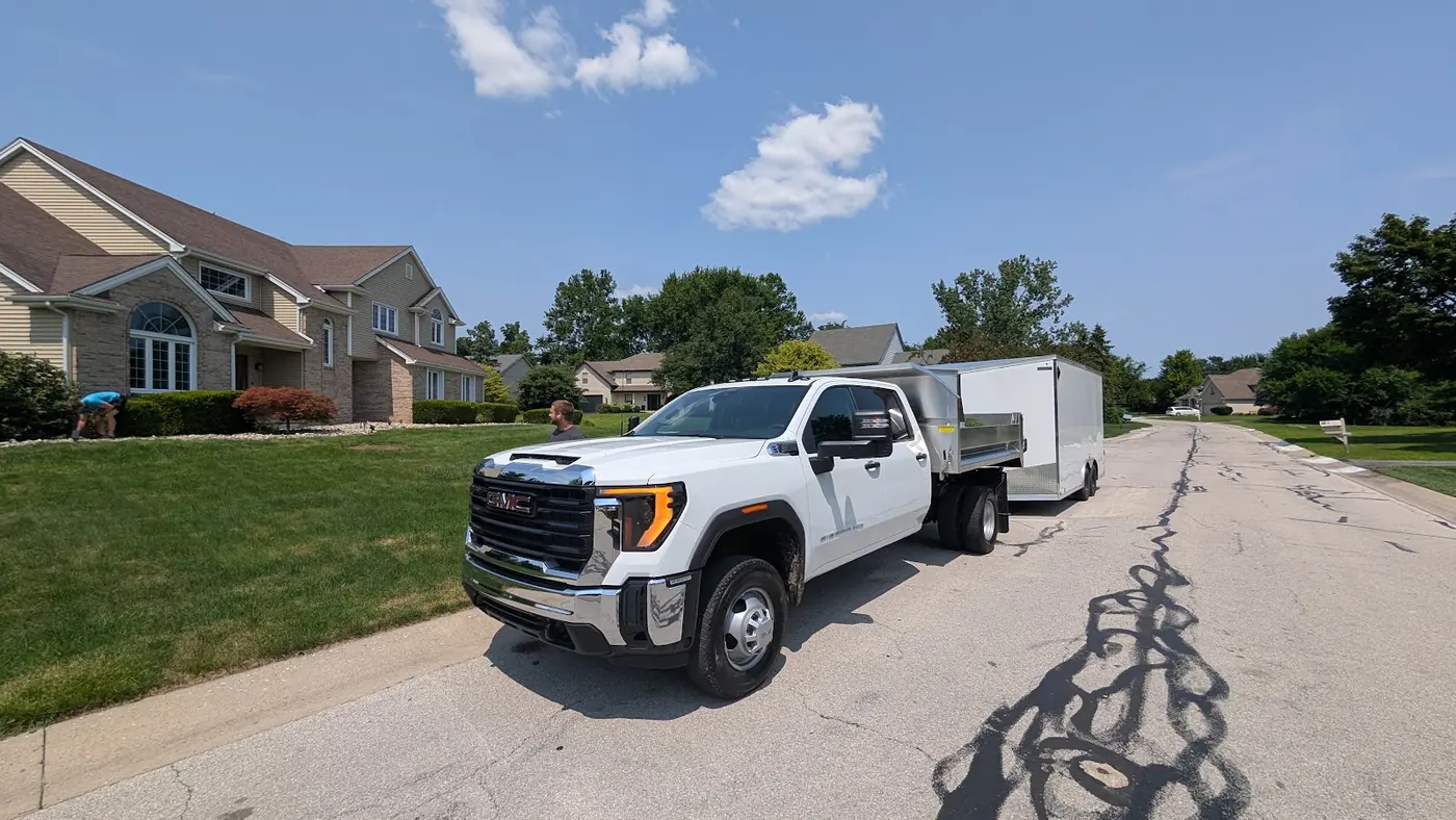 White pickup truck with a trailer parked on a residential street